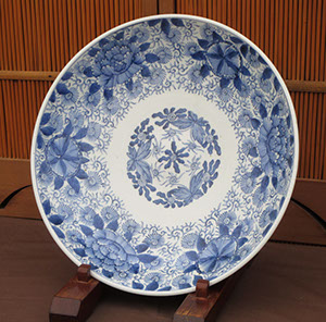 #4189  Large blue-white charger, 15.5"diam x 3"h, all hand painted. Finely detailed flowers, leaves, and vines, front and back, seal on bottom