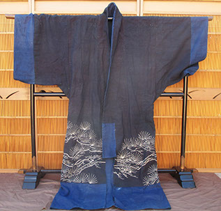 Front view - Heavy dark indigo festival kimono; large paste resist dyed (tsutsugaki) hawk, pine, large three leaf mon, antique mingei fabrics